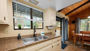 A kitchen with granite countertops, a double sink, and wooden cabinets.