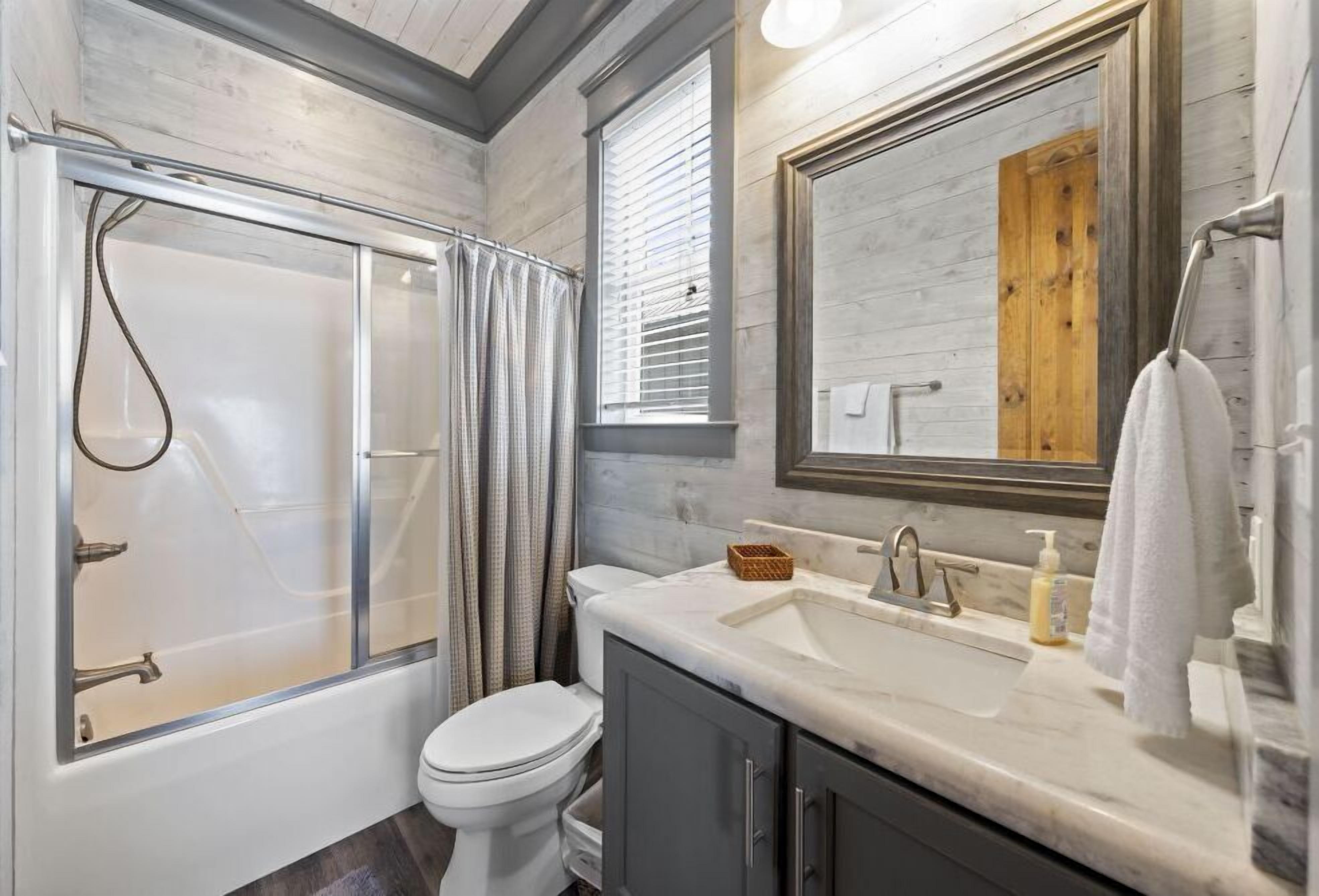 A bathroom with a bathtub, toilet, and sink.