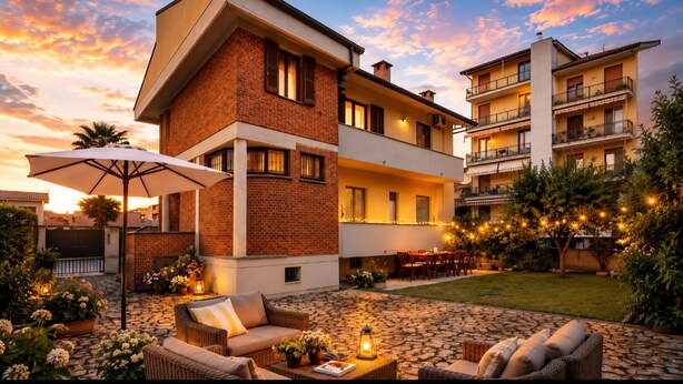 A multi-story residential building with a patio area featuring outdoor furniture and string lights. - Whole house in Magenta | Business, families, Milan/Rho (Magenta)