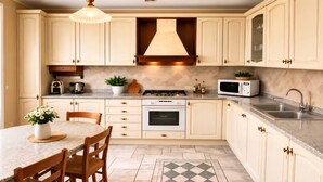 A kitchen with white cabinets, a gas stove, a microwave, and a sink. - Whole house in Magenta | Business, families, Milan/Rho (Magenta)