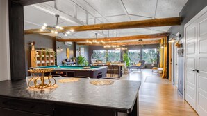 A modern kitchen with a pool table, wooden beams, and a view of the outdoors. - Lakeside Lodge Bay of Fundy (Fairfield)