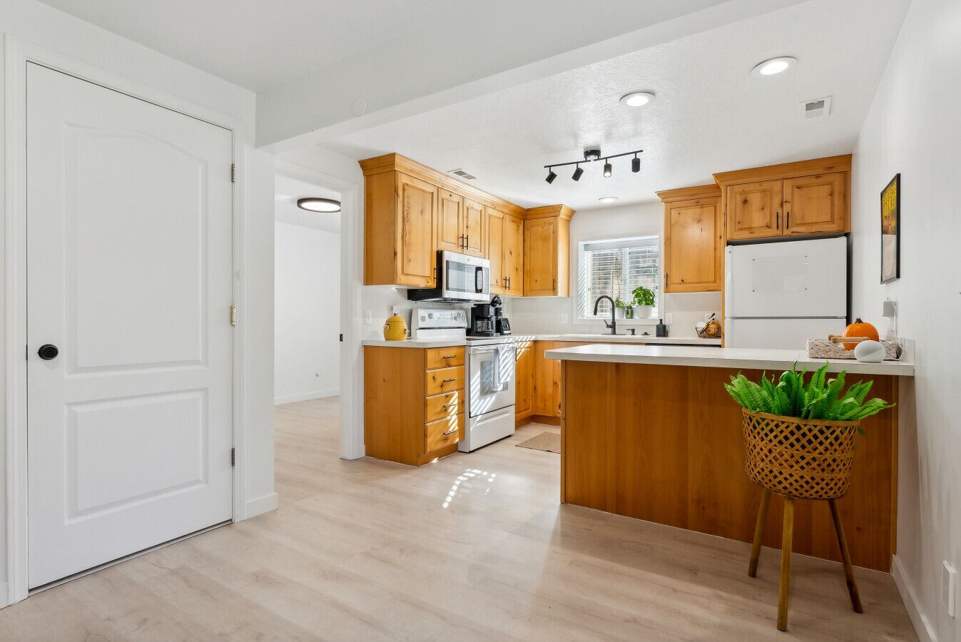 Una cocina moderna con armarios de madera, una isla central y un lavamanos.
