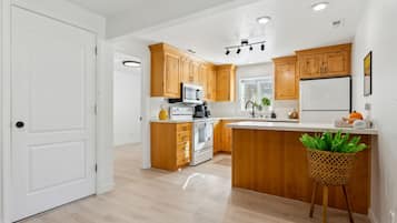 Una cocina moderna con armarios de madera, una isla central y un lavamanos.