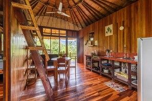 Un intérieur en bois comprenant une cuisine, un coin repas et un escalier.