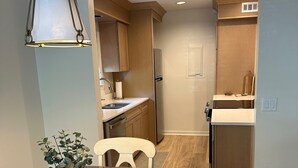 Une cuisine moderne avec des meubles en bois, un réfrigérateur en acier inoxydable et un four encastré.