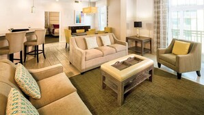 A hotel room with a living area featuring a sofa set, a coffee table, and a dining area with chairs and a table. - Presidential Suite - 4-bedroom awesome hotel suite in fabulous Oceanside (Oceanside)