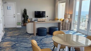 A hotel room with a dining area, a TV, a plant, and a view of the sea. - Presidential Suite - 4-bedroom awesome hotel suite in fabulous Oceanside (Oceanside)