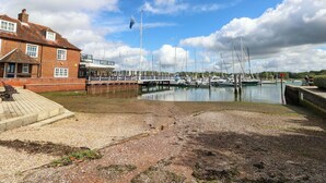 A marina with boats docked, a brick building, and a clear sky. - The Old House (Southampton)