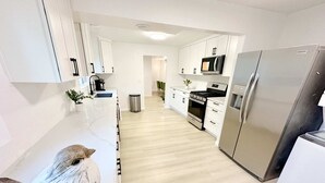 A modern kitchen with white cabinets, stainless steel appliances, and a wooden floor. - 2 Private Acres - 2 Houses - 5 Bed Rooms 4 Bath - 2 Kitchens - Single Level  (Hillsboro)