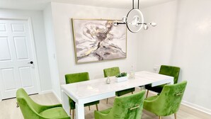A dining area with a white table, green upholstered chairs, and a modern chandelier. - 2 Private Acres - 2 Houses - 5 Bed Rooms 4 Bath - 2 Kitchens - Single Level  (Hillsboro)
