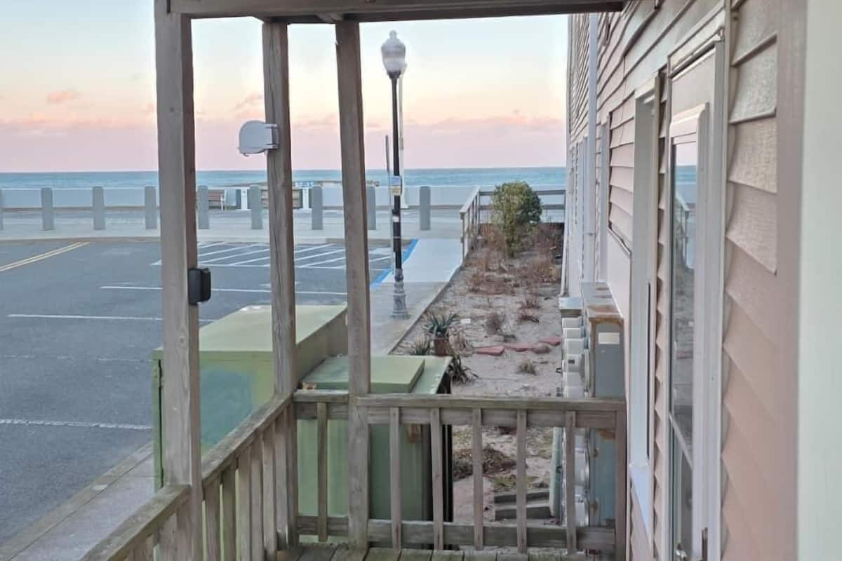 A wooden deck with a view of the ocean and a bridge.