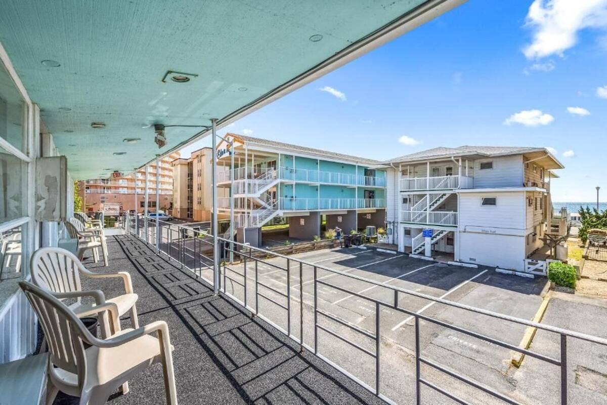 A hotel with a covered outdoor area, multiple floors, and a parking lot.