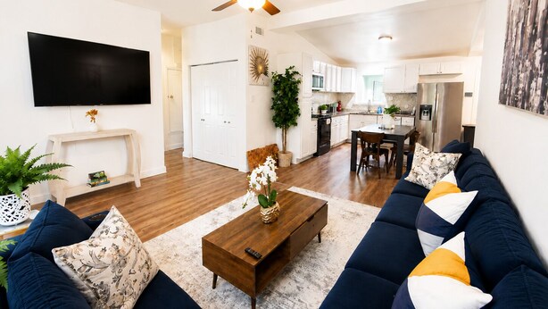 A modern living room with a sofa, coffee table, and TV. - Entire Spacious and beautiful 5 Bedroom House (Garland)
