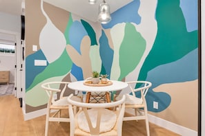 A round table, a colourful mural and time for one more coffee. This little dining nook has plenty of personality. - Kensington Art Suite | King Bed & Private Entry (Calgary)