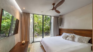 Ein Schlafzimmer mit einem großen Bett, einem Holzkopfende und einem Deckenventilator.