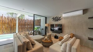 Ein modernes Wohnzimmer mit großem Fenster, Flachbildfernseher und Couchtisch aus Holz.