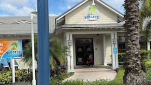 Un edificio con un letrero que dice "Breezes restaurant & bar" y una palmera al frente.