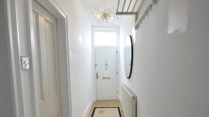 A narrow hallway with a beige carpet and white walls. - Enchanting 3-bedroom house in Stockport (Stockport)