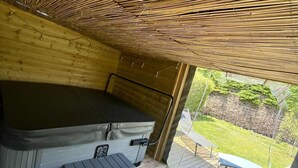 Un interior de madera con un jacuzzi, una mesita y una silla.