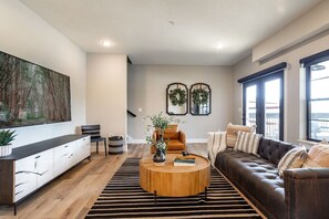 Ein modernes Wohnzimmer mit einer Couch, einem Couchtisch und Kunstwerken an der Wand.