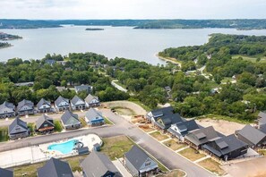 Un quartier résidentiel avec des maisons, une piscine et un lac en arrière-plan.