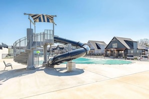Une structure de toboggan aquatique, une piscine et des immeubles résidentiels.