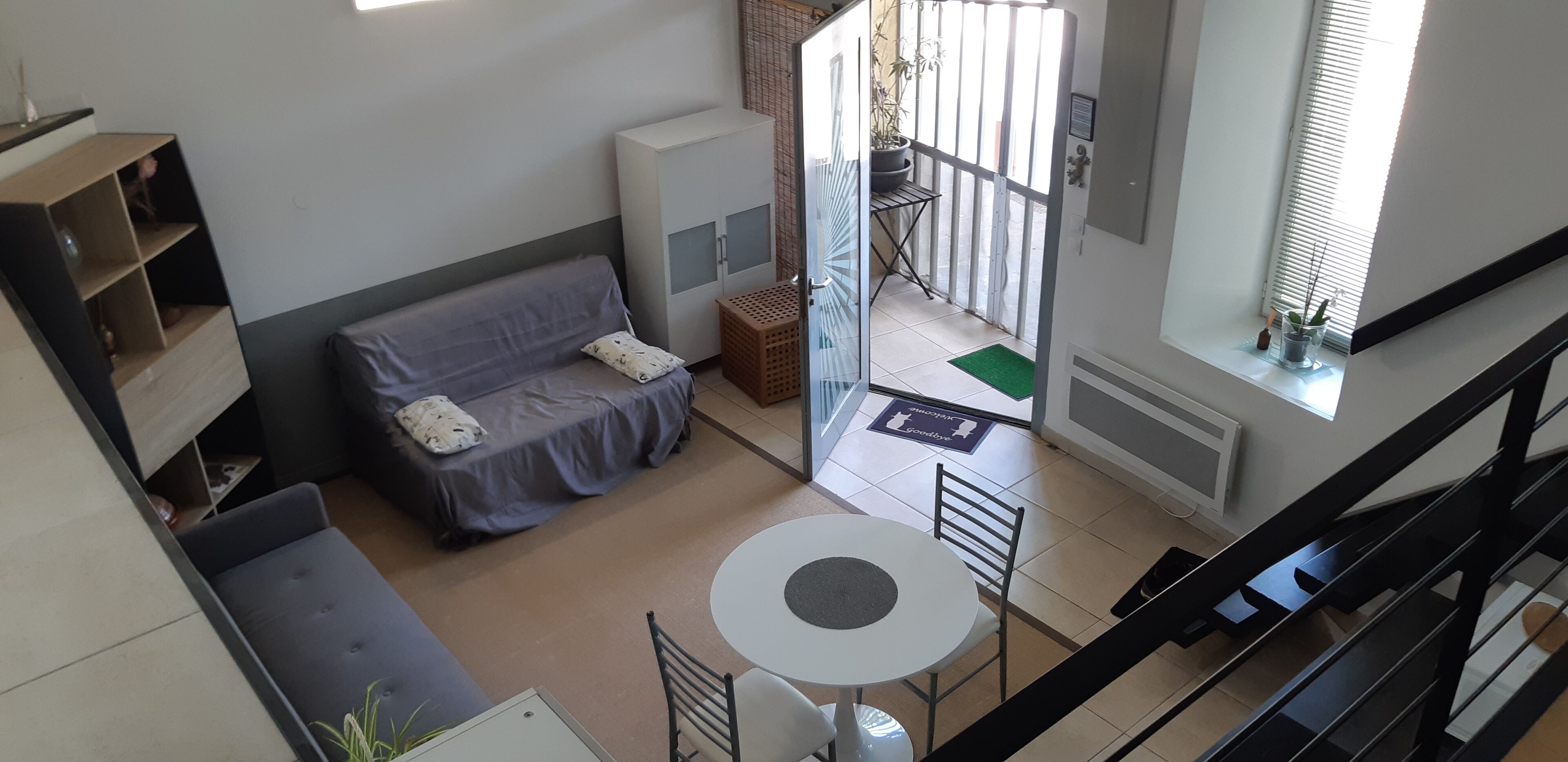 Un espace de vie compact comprenant un canapé, une petite table et un meuble.