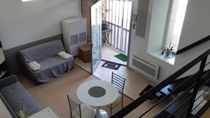 Un espacio habitable pequeño con sofá, una mesita y un armario.
