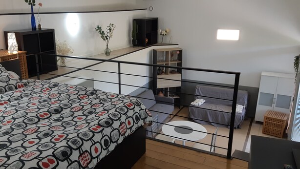 Un dormitorio moderno con cama, balcón y vista a la ciudad.