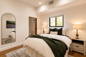 A bedroom with a bed, two bedside tables, a nightstand, a mirror, and a window. - Hacienda Style Home, Swimming Pool, Hot Tub, Outdoor BBQ Area, Fire Pits (Salinas)