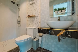 Ein Badezimmer mit Toilette, Dusche, Waschbecken und einem Spiegel mit Pflanzen.