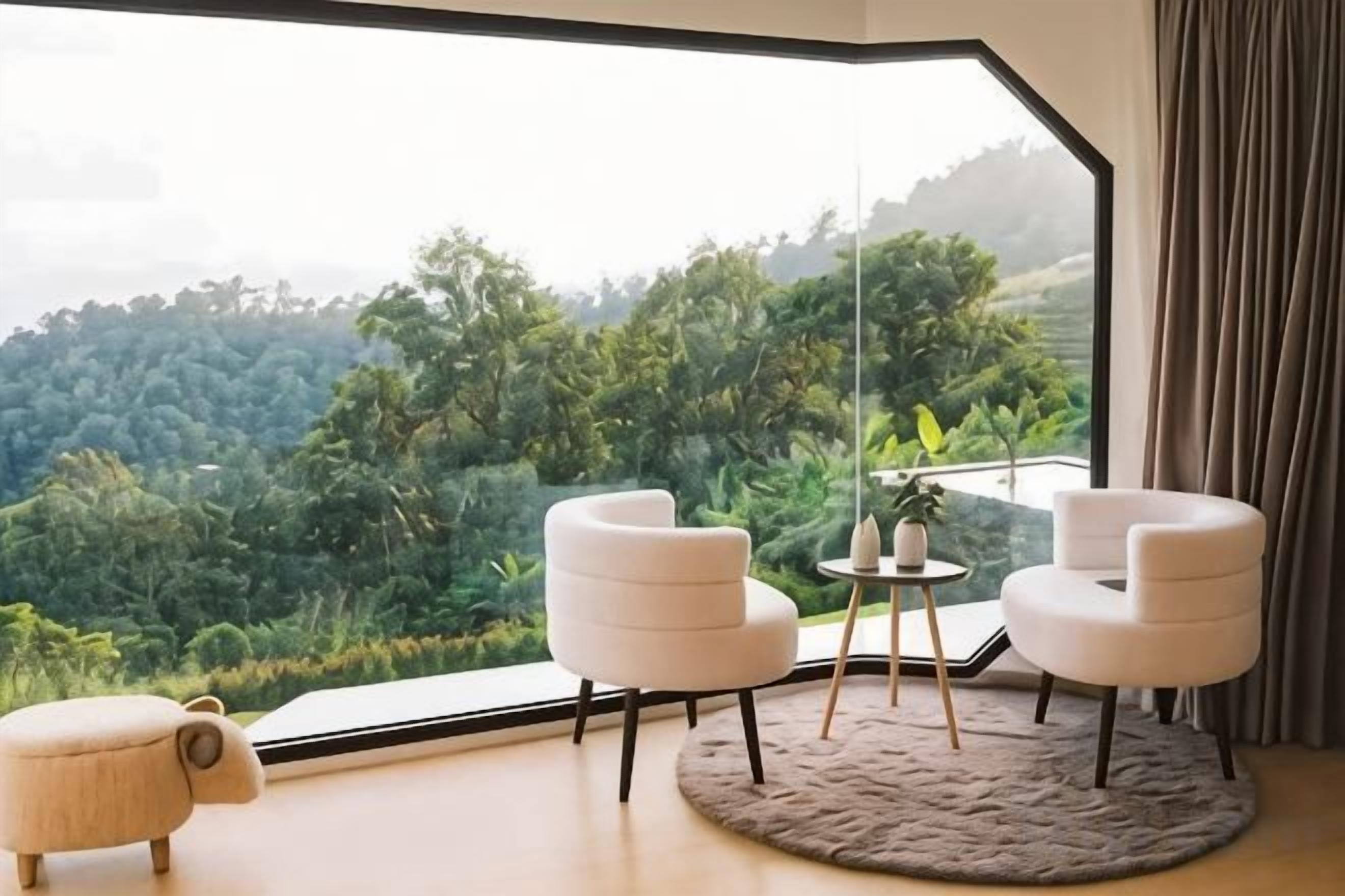 Una habitación con un ventanal grande, dos sillas blancas, una mesita y un tapete redondo.