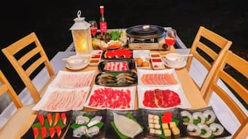 Una mesa preparada para una comida con diferentes platos, un farol y una parrilla.
