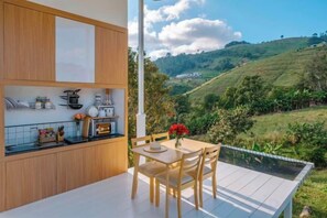 Una cucina moderna con mobili in legno e zona pranzo con vista su un paesaggio collinare.