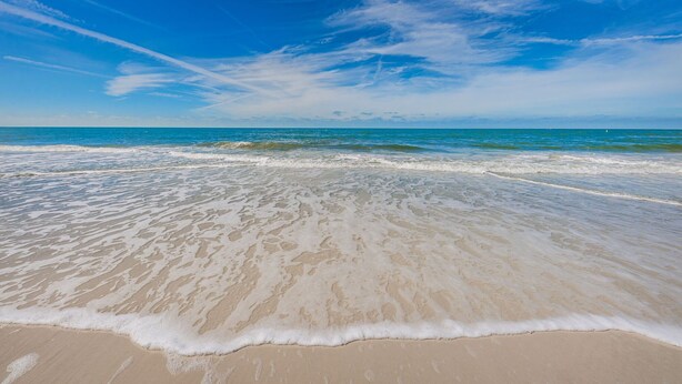 A beach with clear skies and gentle waves. - New listing Spacious 4-Bedroom beach cottage steps from the beach (Indian Rocks Beach)