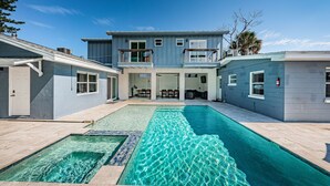 Ein zweigeschossiges Haus mit Pool im Garten.