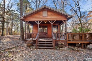 A wooden cabin with a porch and steps leading to the entrance. - Rustic Retreat W/ Hot Tub • Firepit - BBQ (Broken Bow)
