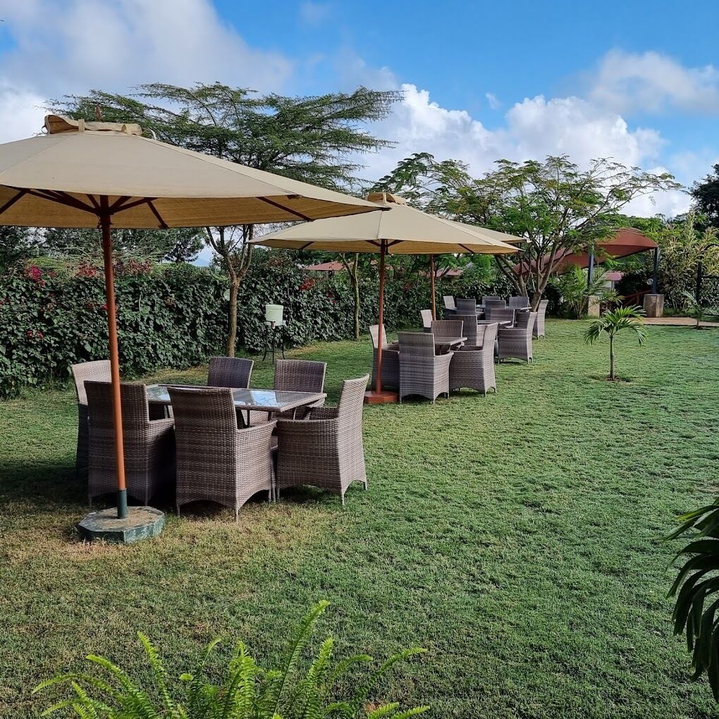 An outdoor seating area with wicker furniture and umbrellas.