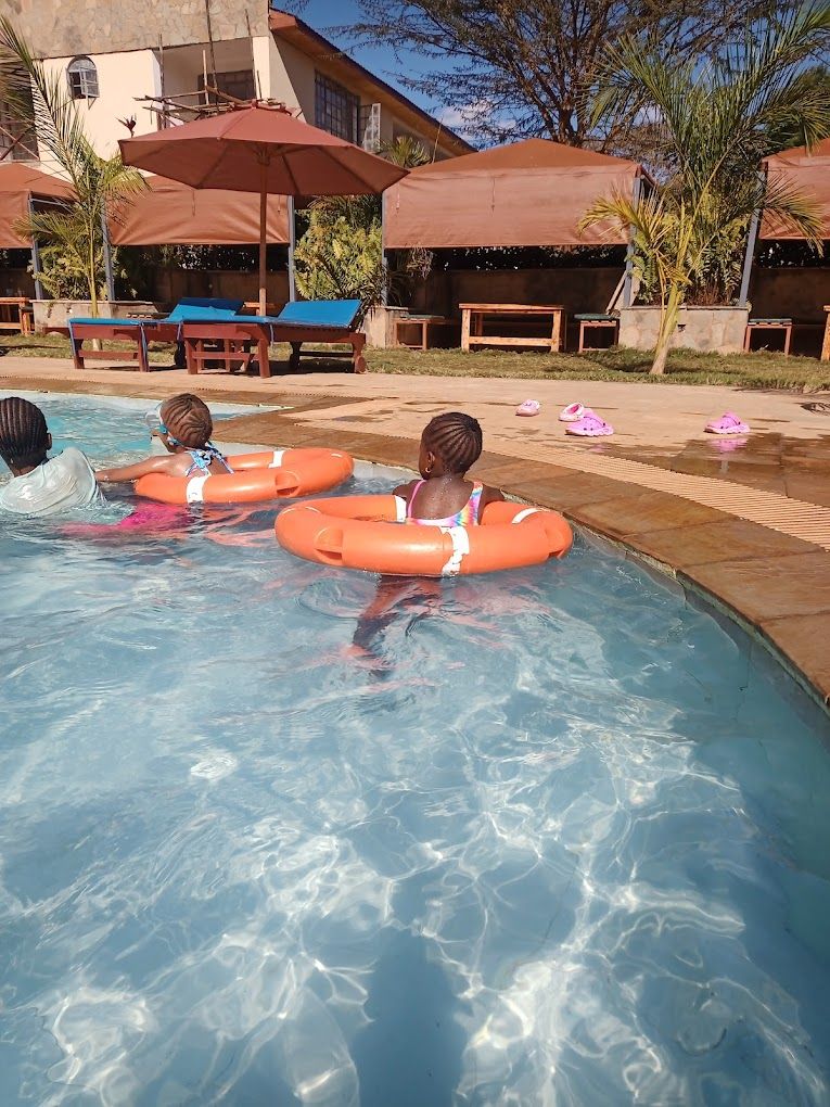 Un área de piscina con sillas de descanso y sombrillas.