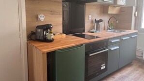 A modern kitchen with a built-in coffee maker, a sink, and a stove. - Apartment in the heart of Le Creusot (Le Creusot)