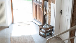 A spacious entryway with a wooden door, a white bench, and a welcome mat. - Idyllic vacation home in the countryside in the Rhön (Oberthulba)