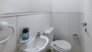 Een kleine, schone badkamer met toilet, wastafel en bidet.