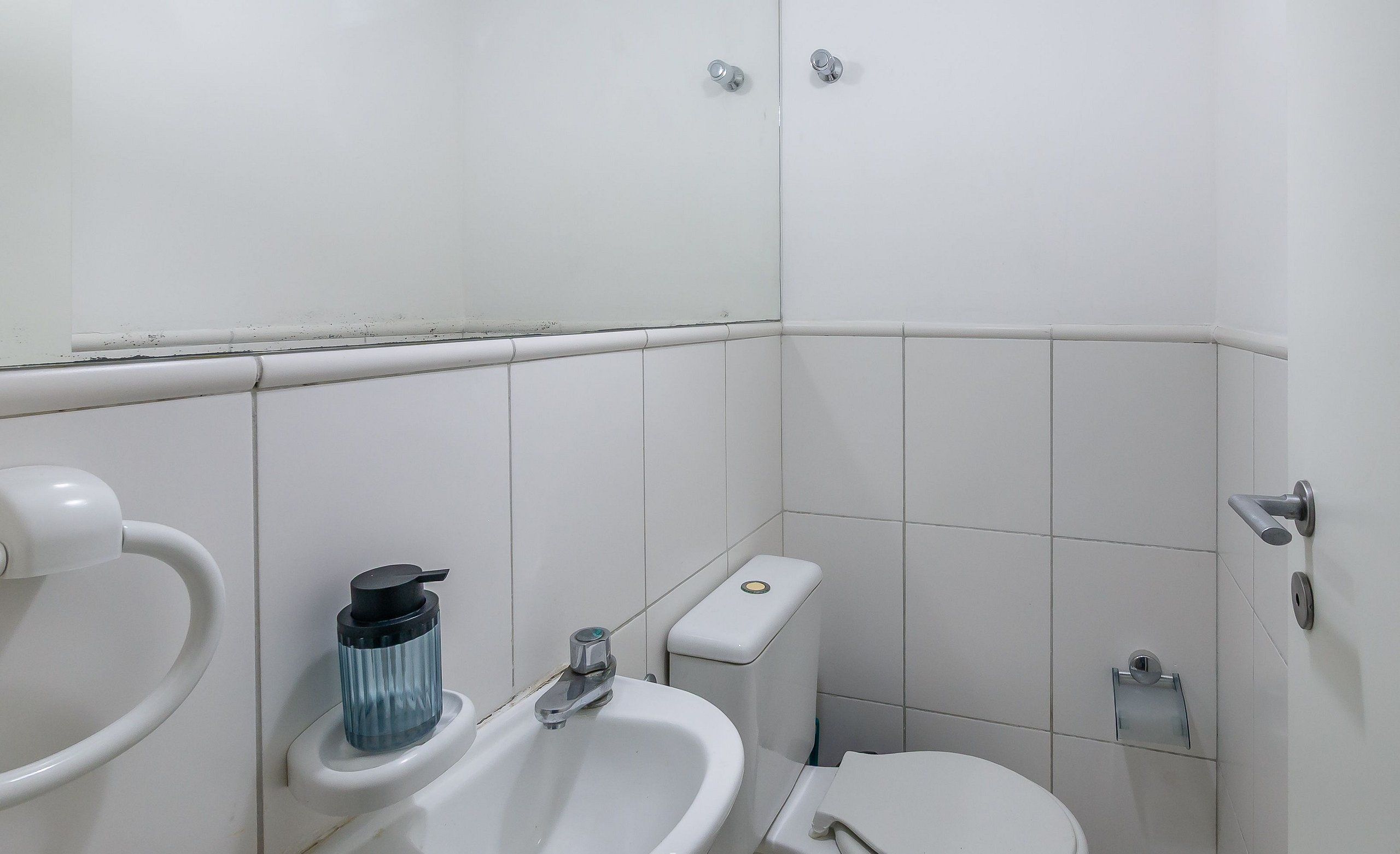 A small, clean bathroom with a toilet, sink, and bidet.