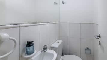 Een kleine, schone badkamer met toilet, wastafel en bidet.