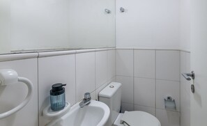 A small, clean bathroom with a toilet, sink, and bidet. - Modern apt 200m From the sea in Salvador Vlt0107 (Salvador)