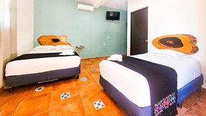 A room with two beds, a television on the wall, and a door. - Hotel Mayas Blue (Bacalar)