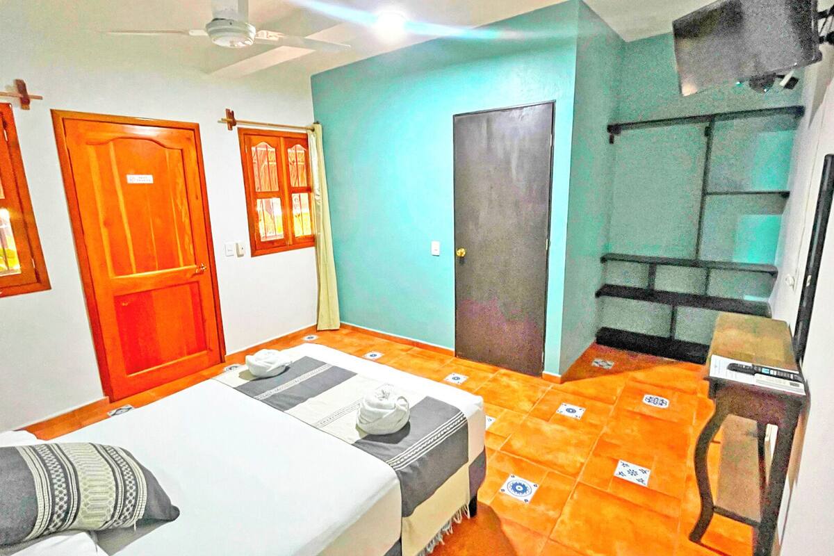 A room with a bed, a desk, and a wardrobe.