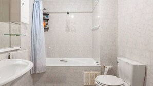 A modern bathroom with a bathtub, toilet, and sink. - A place to rest (Gualtar)