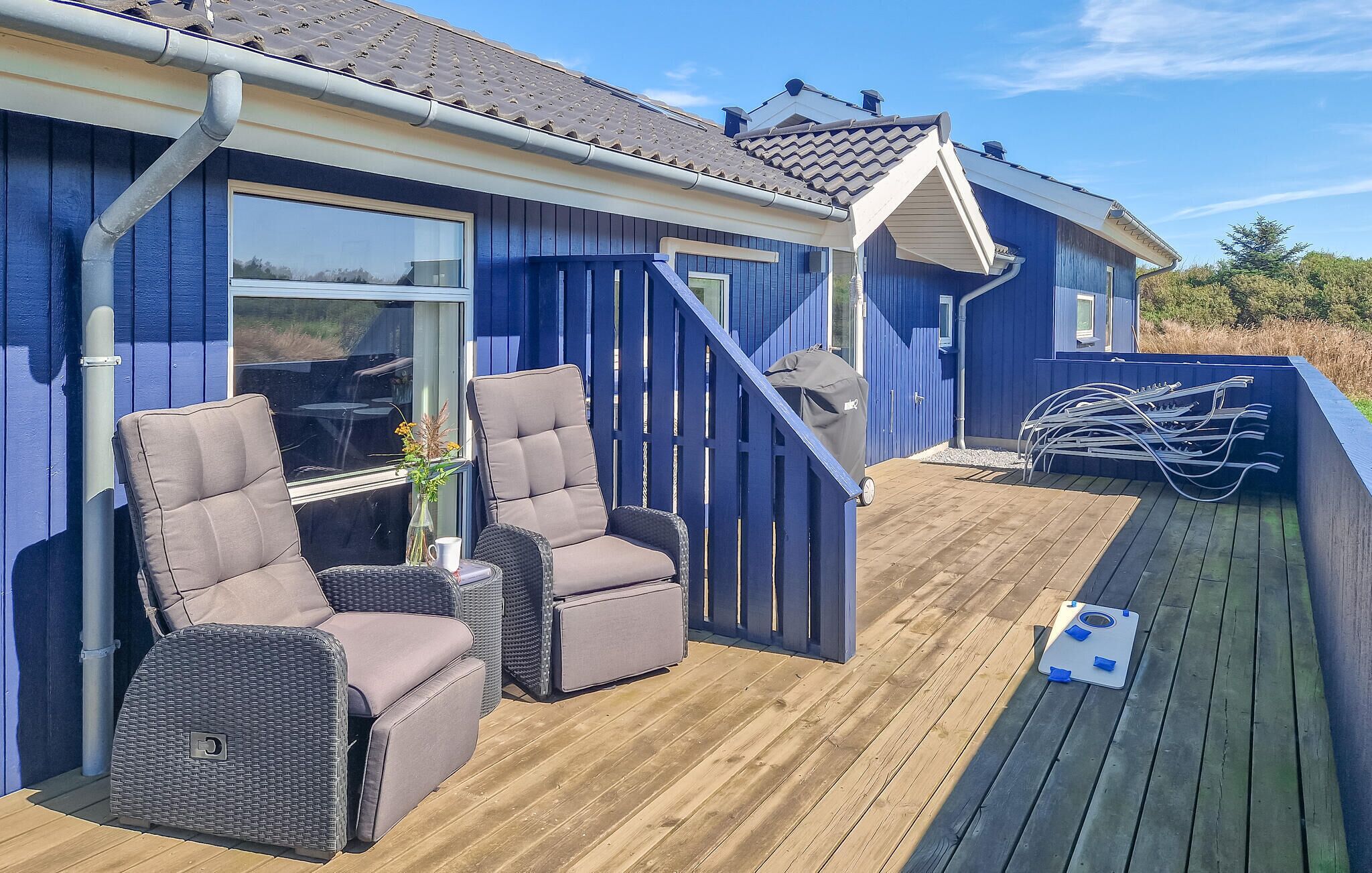 A deck with outdoor furniture, a grill, and a pool table.