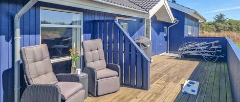 A deck with outdoor furniture, a grill, and a pool table.